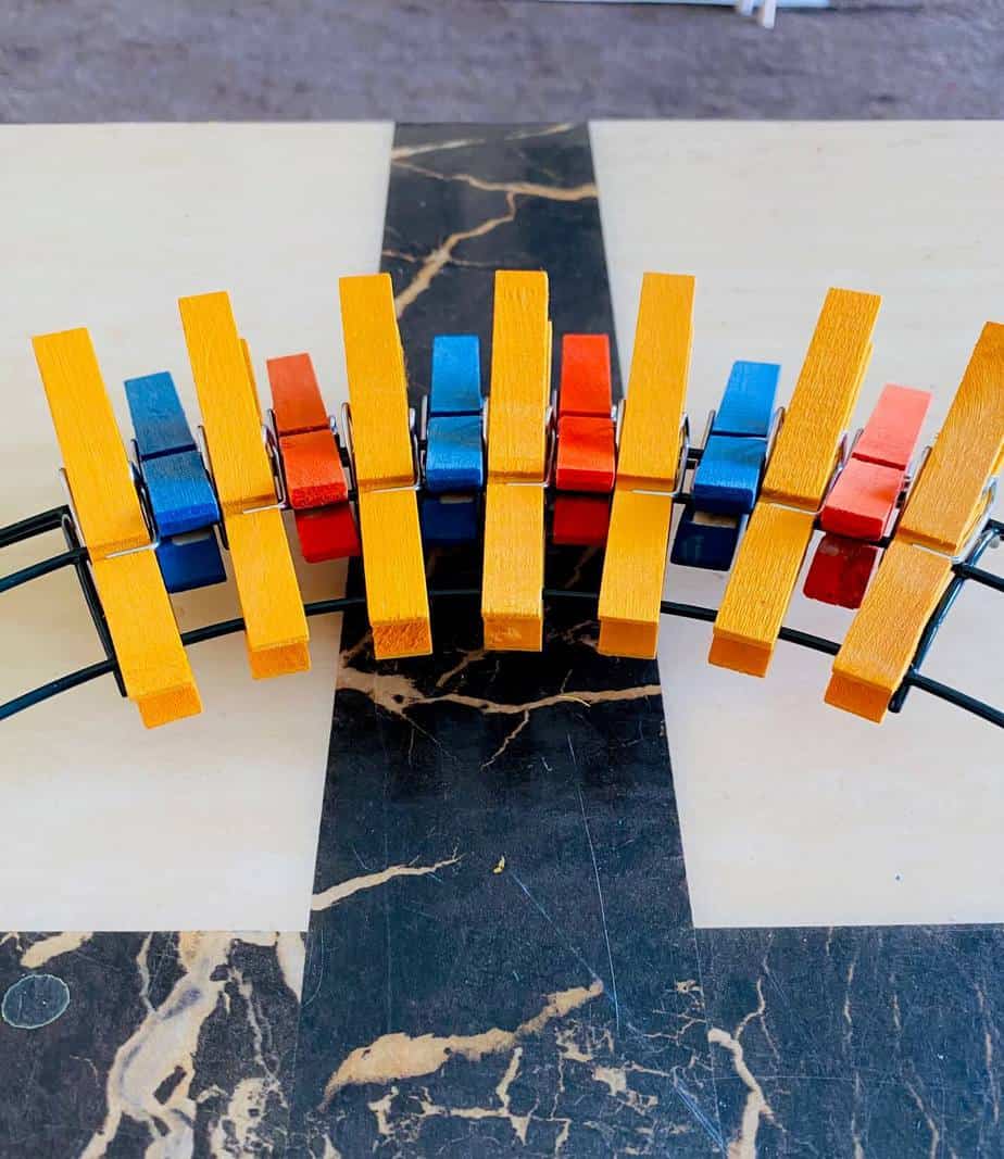 Continue to place yellow clothespins on the inner two wires of the wreath form, and orange or blue on the middle two layers until you reach the end of the section.