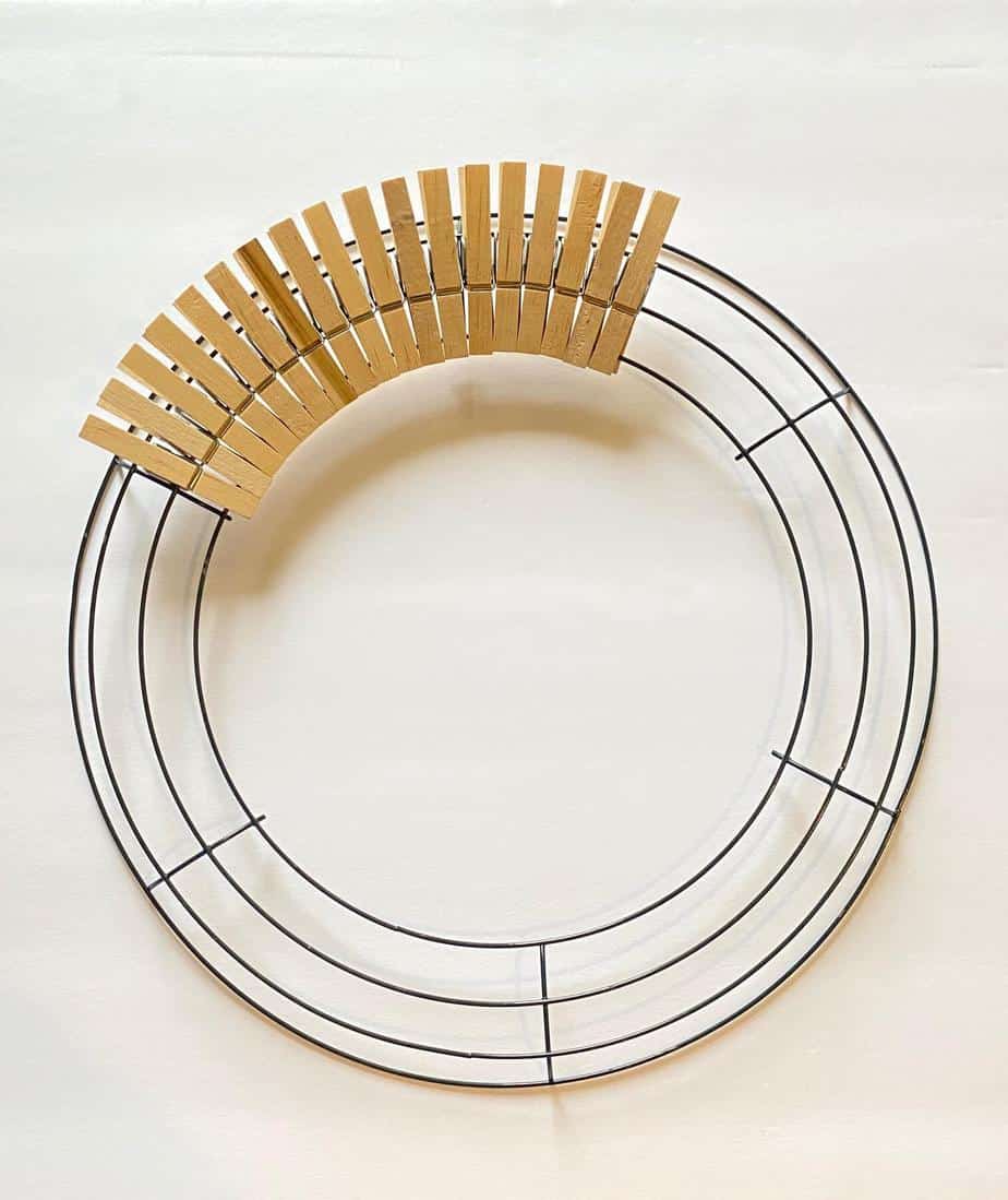Arrange the naked wooden clothespins around the wire wreath form in a single layer