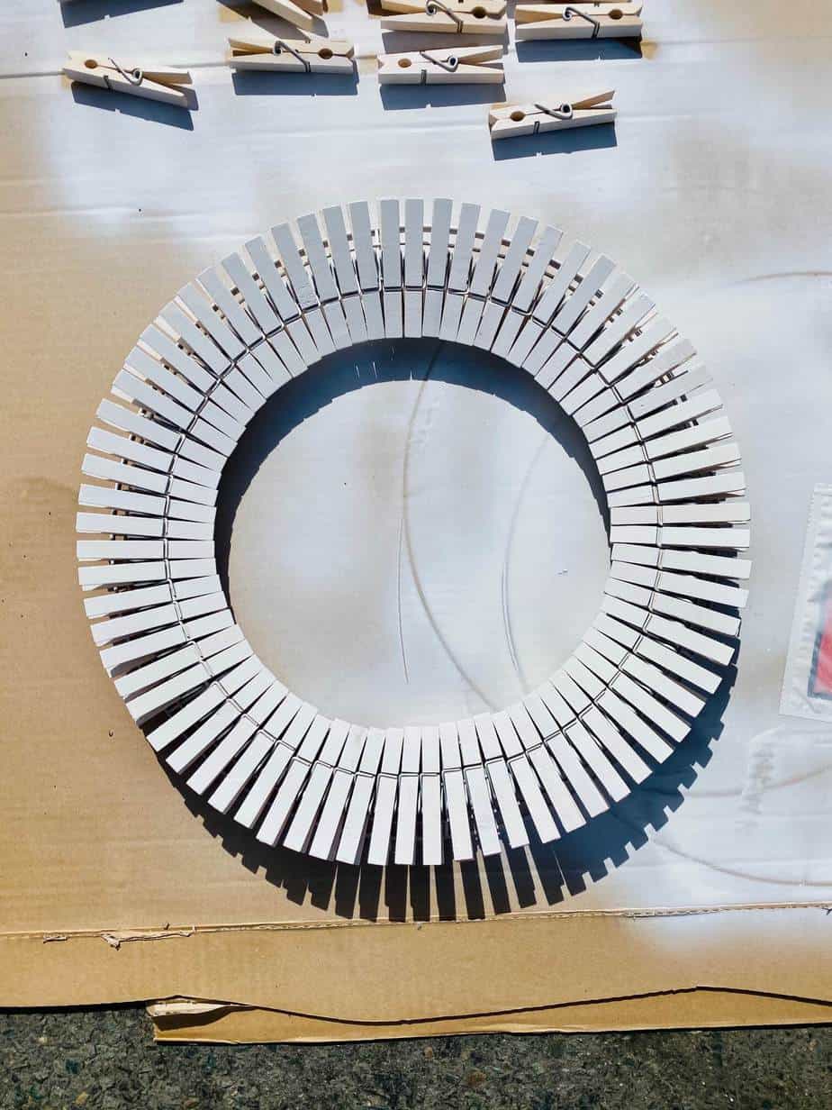 Spray paint the entire wreath frame and clothespins white to make the base of the 4th of July DIY dollar tree wreath