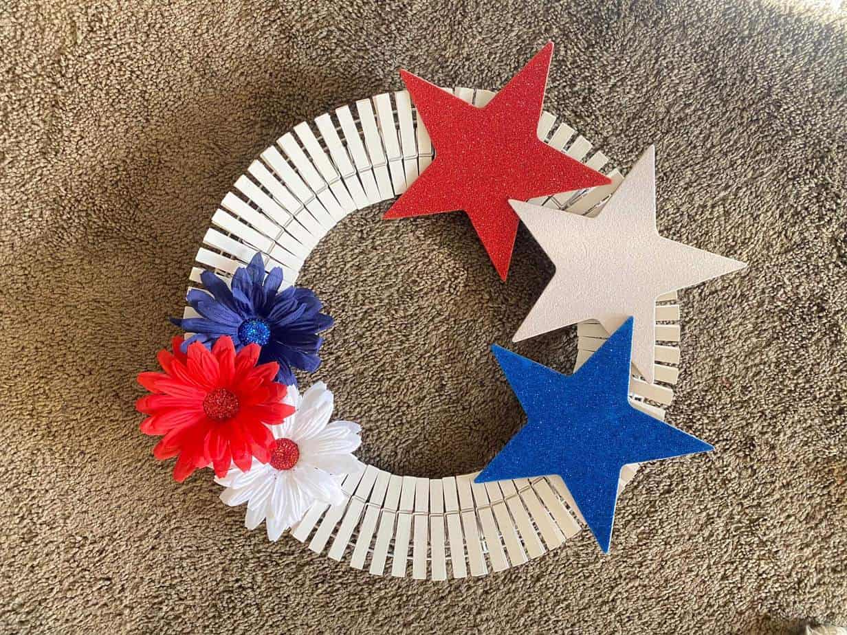 Glue the stars and flower embellishments to the white clothespins to complete the dollar tree 4th of july clothespin wreath