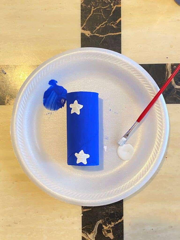 Paint white stars onto the blue painted toilet paper roll
