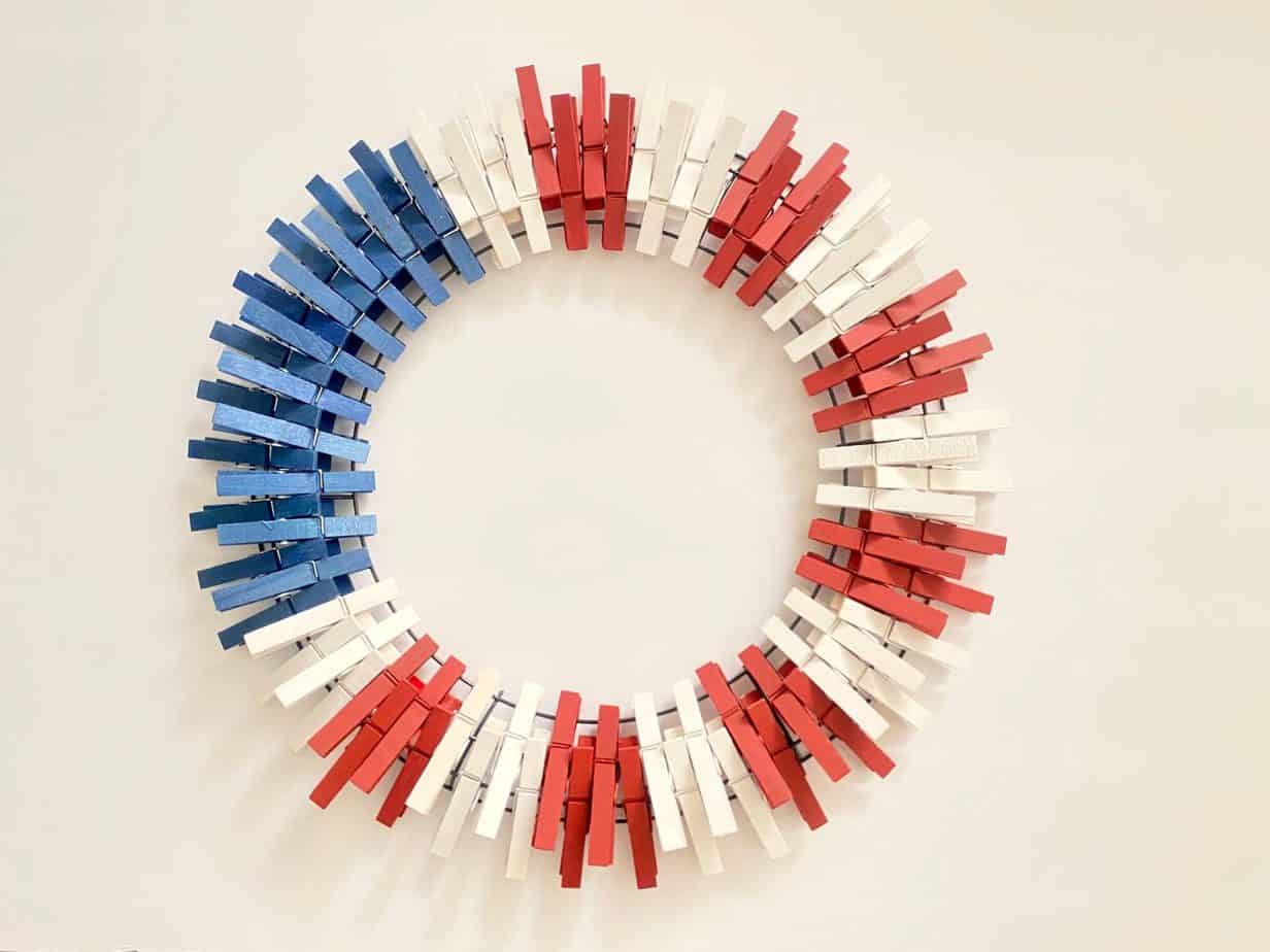 Patriotic clothespin wreath with all the red white and blue clothespins pinned onto the wire wreath form
