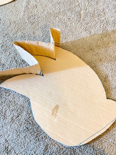 Begin to shape the long, bendy cardboard piece around the outline of the Sonic, securing with masking tape every 1-2 inches.