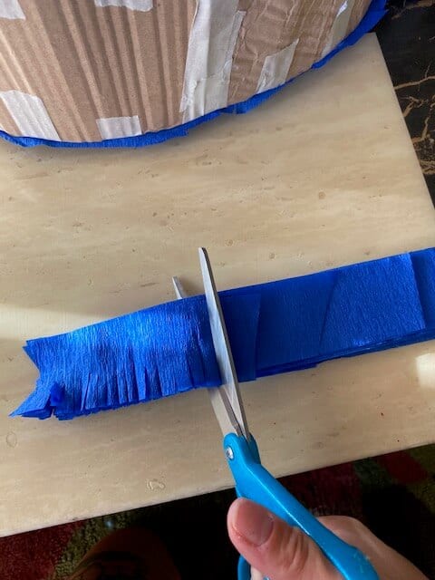 Use scissors to cut fringe all along each strip of crepe paper