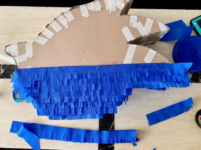 Cut and glue strips of blue crepe paper across the front of the Sonic, starting from the bottom and working your way up