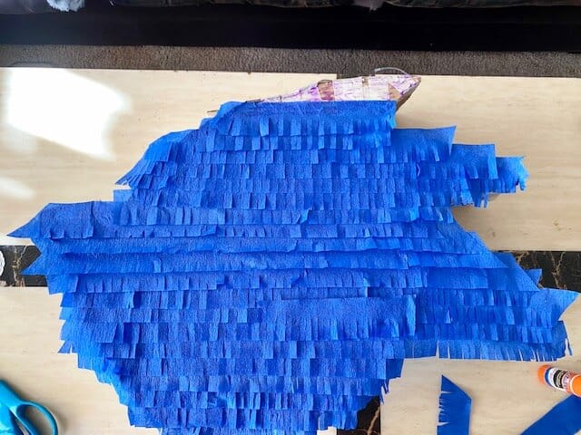 Cut and glue strips of blue crepe paper across the front of the Sonic, starting from the bottom and working your way up