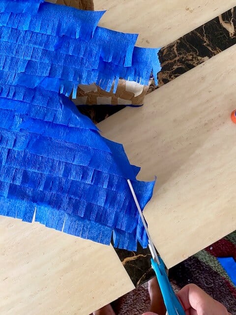 Trim the extra blue crepe paper overhang from around the Sonic outline