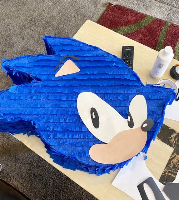 Draw and cut out the pieces for Sonics face out of card stock and glue in place on front of Pinata