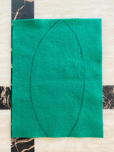 Draw the outline of the palm tree leaf onto the green felt