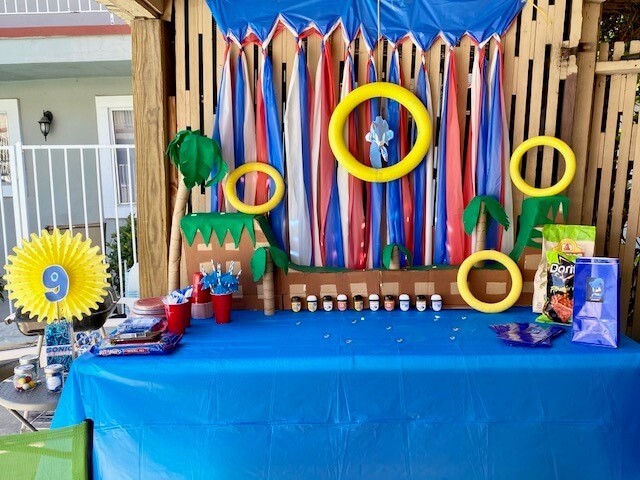 DIY sonic the hedgehog ramp birthday party prop to look like the sega game. DIY palm trees and sonic golden rings.