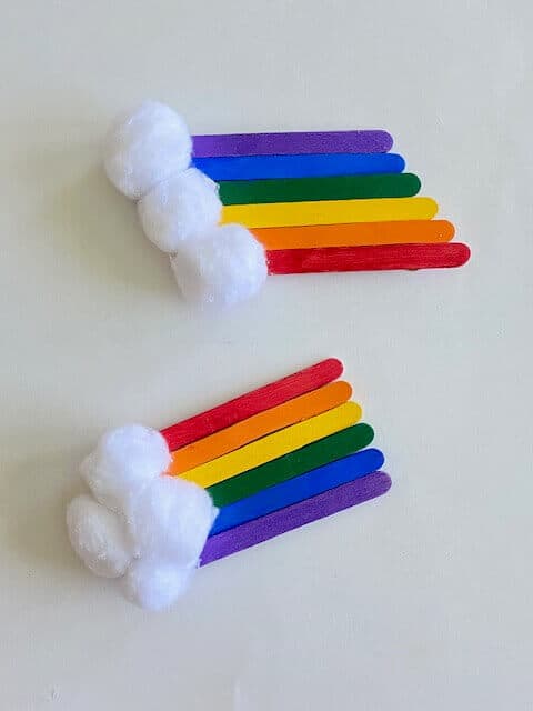 Glue cotton balls to one end of the popsicle stick rainbow