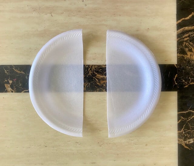 Cut the paper plate in half to make 2 paper plate fans