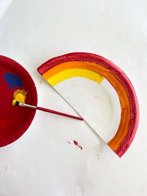 Paint the outer most curve red and work your way in following the colors of the rainbow until you get to the center of the fan