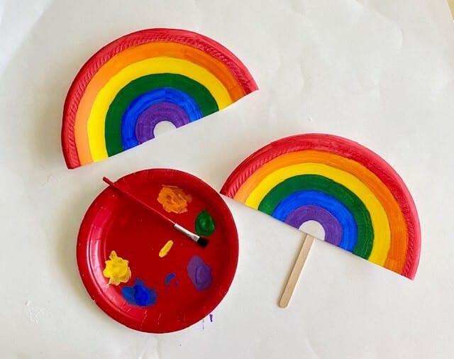 Glue a popsicle stick to the back of the rainbow paper plate fan