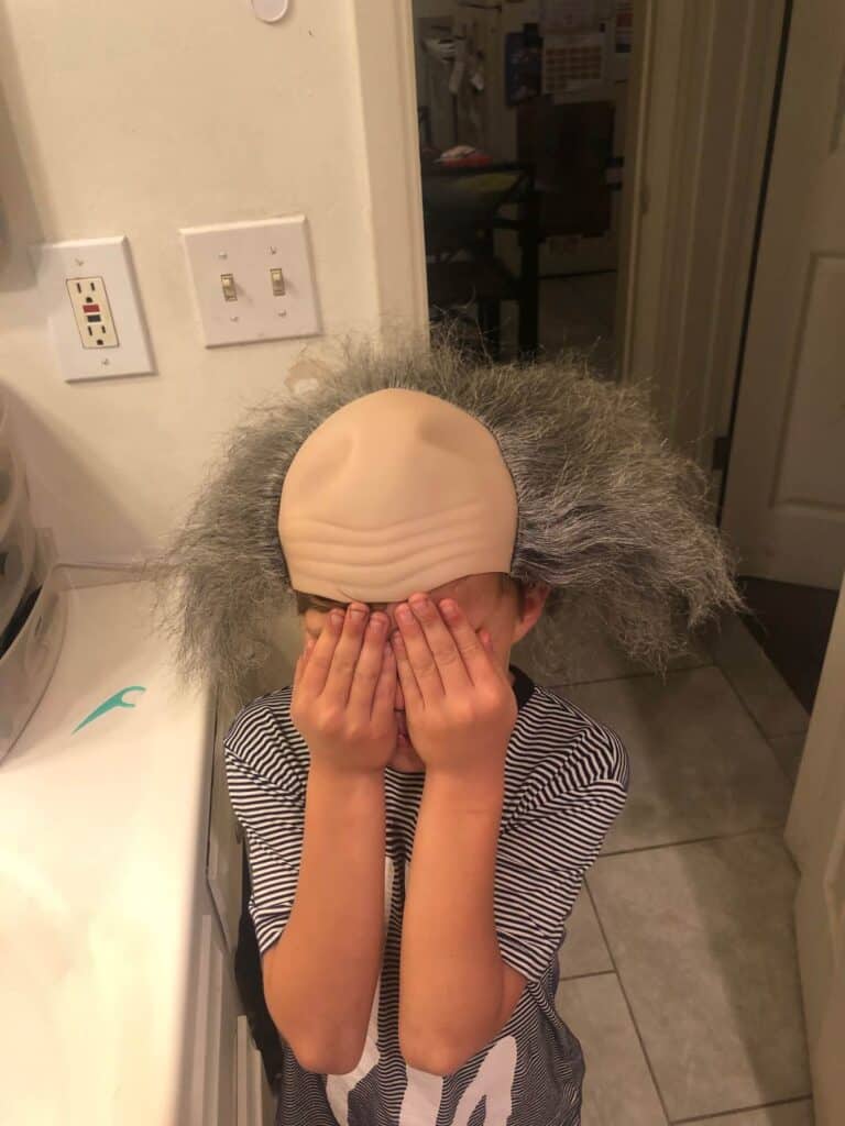 Bald old man wig on my sons head to see how it fits and make a plan for how to turn it into a pennywise wig.