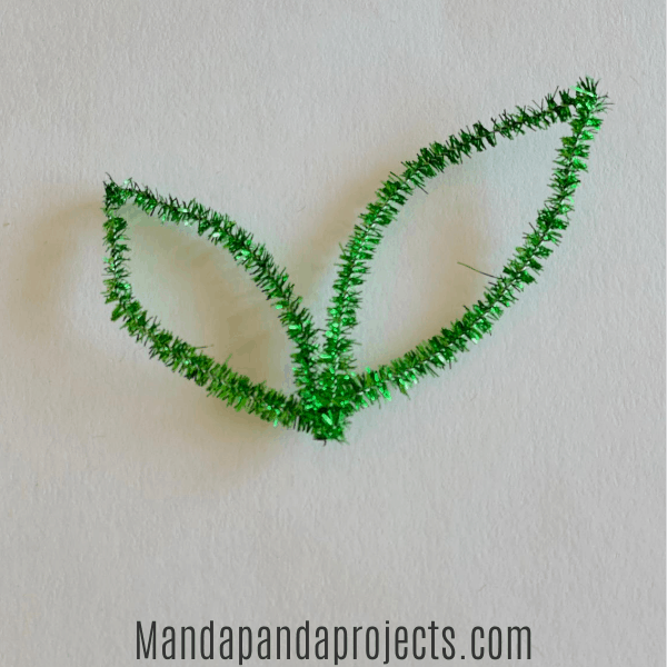 Bend and twist a green pipe cleaner into the shape of a leaf to add to the pumpkin stem.