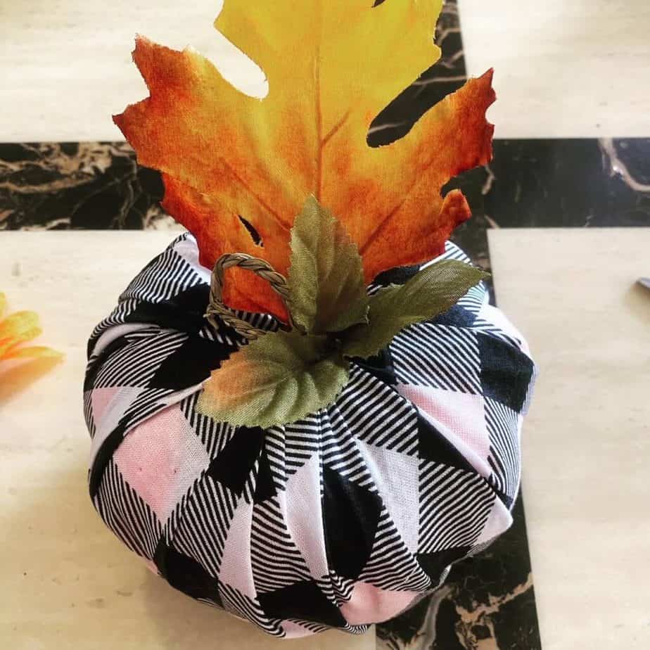 Add some twine, a faux leaf, or a "stem" of your choice in the center of the fabric covered dollar tree foam pumpkin.