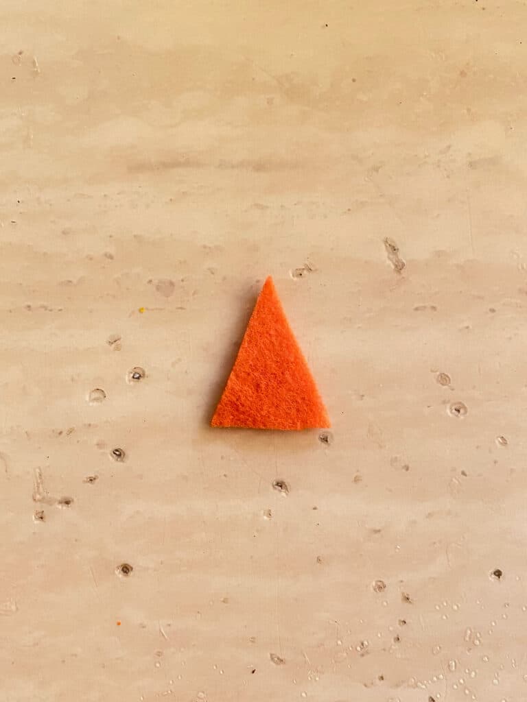Cut an orange triangle out of felt to make the scarecrows nose.