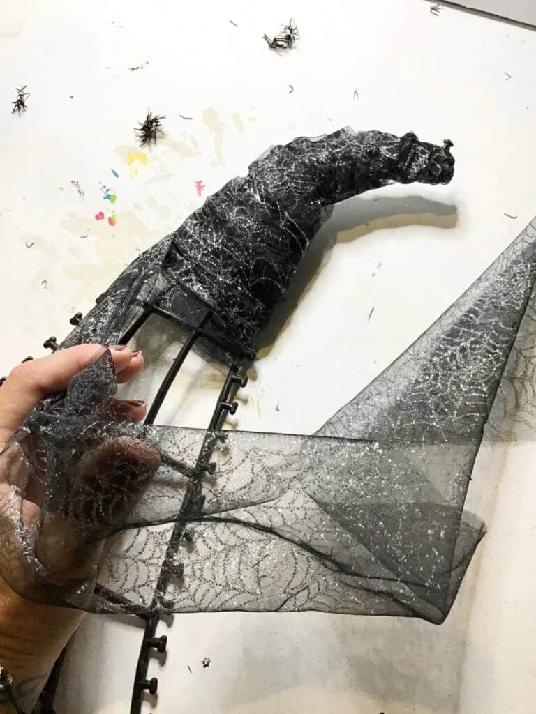 Continue to wrap around diagonally until the top portion of the plastic Witch Hat frame is covered with black tulle.