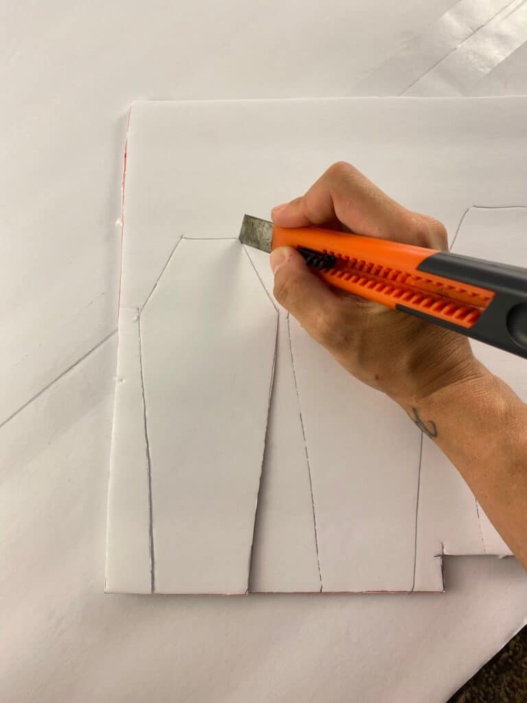 Trace the shape of the coffin onto foam board, and use an X-acto knife to cut out the shapes. 
