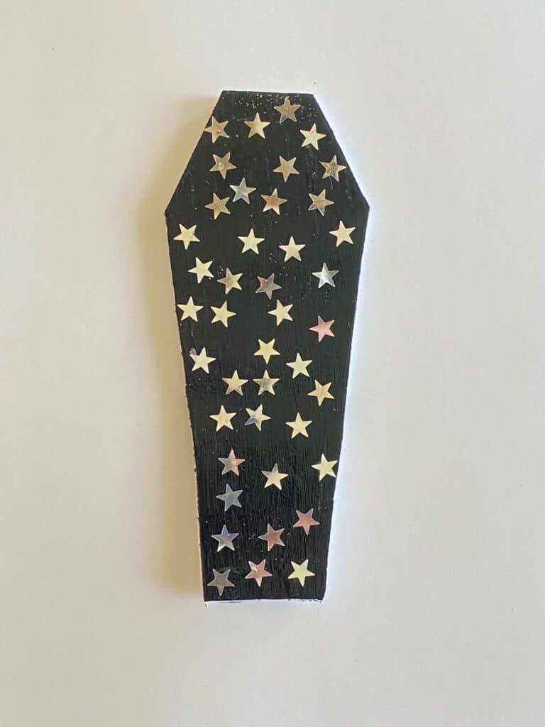 Black painted foam board coffin with silver metallic stars.