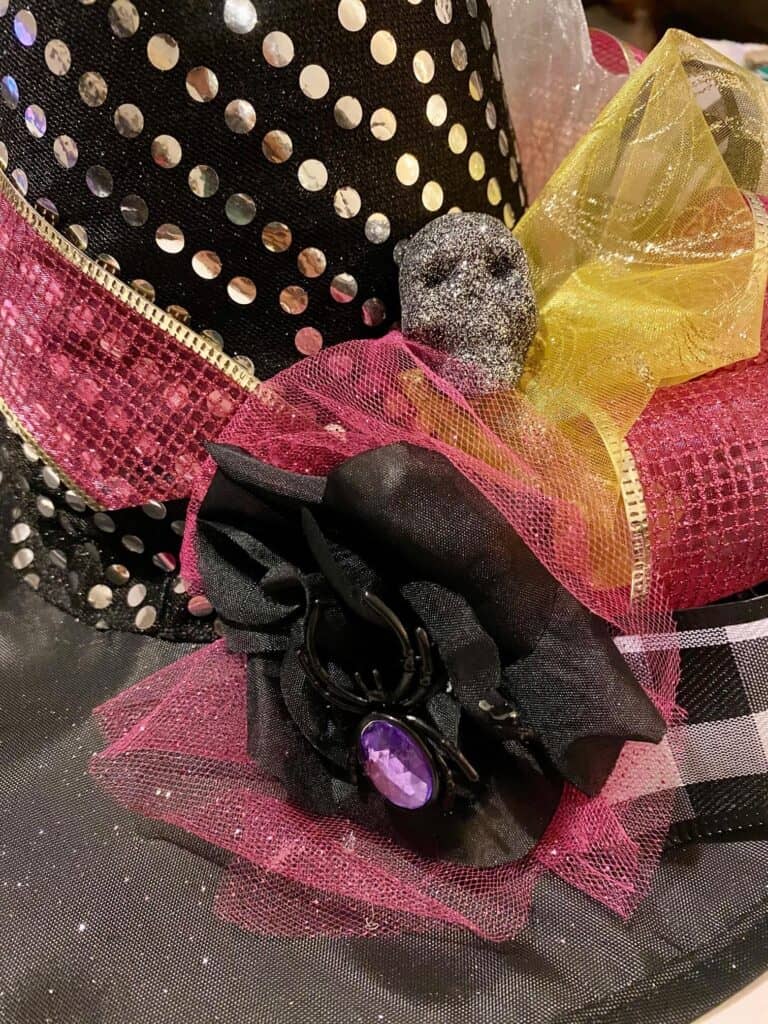 Dollar Tree black witch hat with a black faux rose and silver glitter skull.