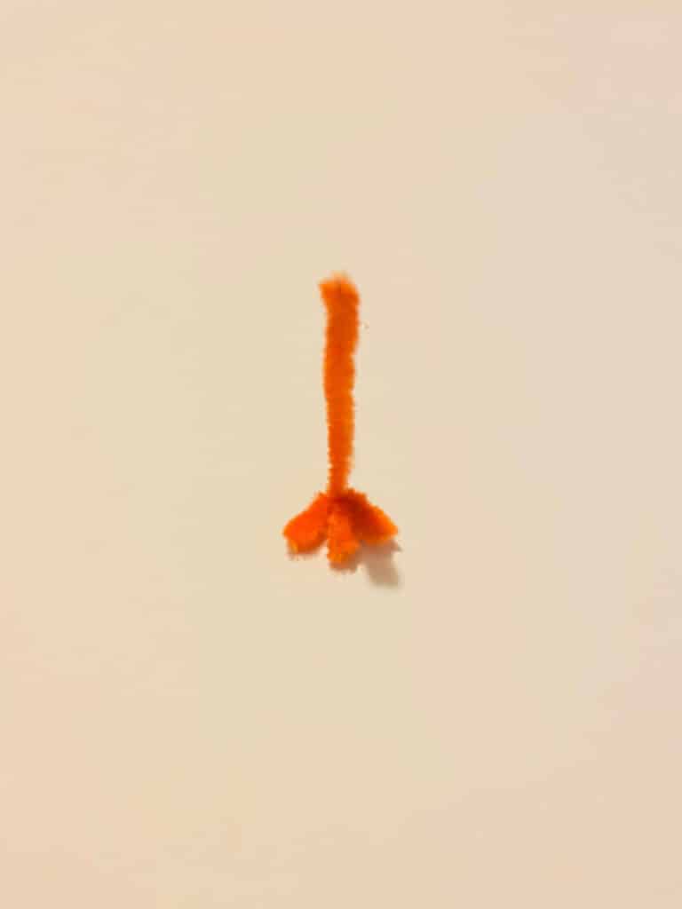 Half of an orange pipe cleaner bent in  a zig zag at one end to make a turkey claw.