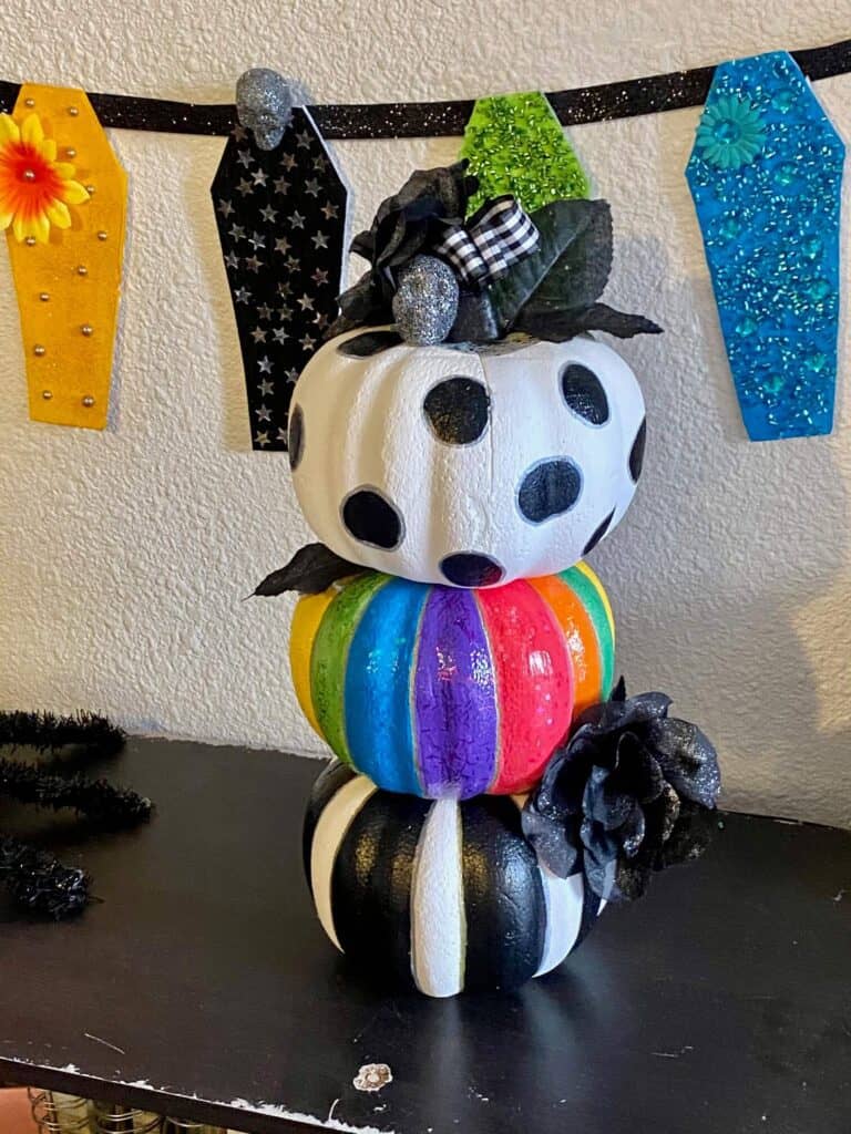 DIY Dollar tree foam pumpkin rainbow color and black and white topiary with black faux roses and silver glitter skulls to decorate for Halloween.