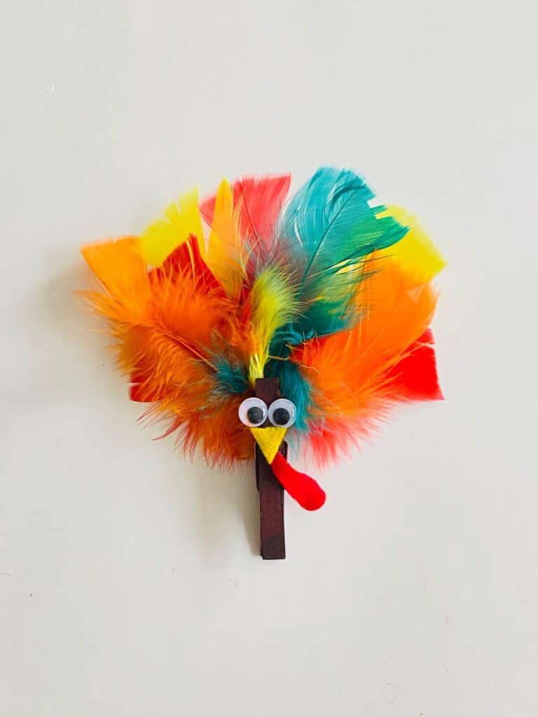 Clothespin turkey craft with feathers.