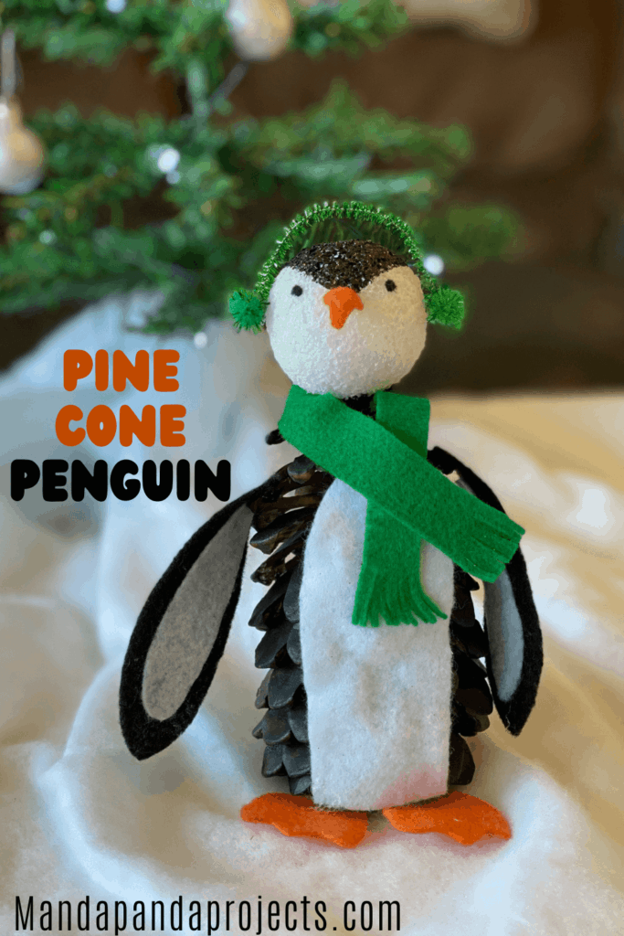 Pine Cone Penguin nature christmas craft for kids with felt winter scarf and earmuffs.