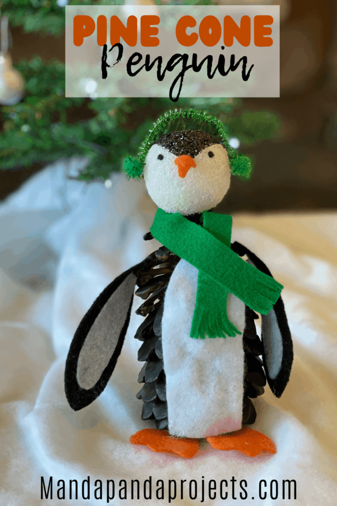 Pine Cone Penguin Christmas nature craft for kids with felt winter scarf and earmuffs.