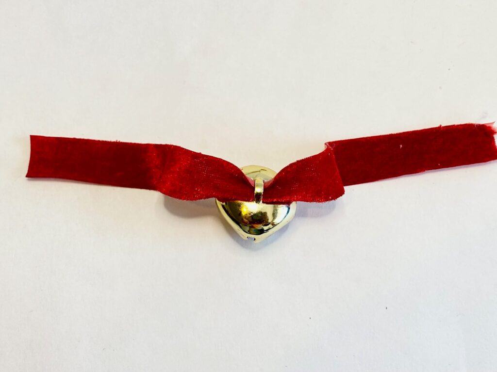 Red velour ribbon collar with a gold jingle bell.