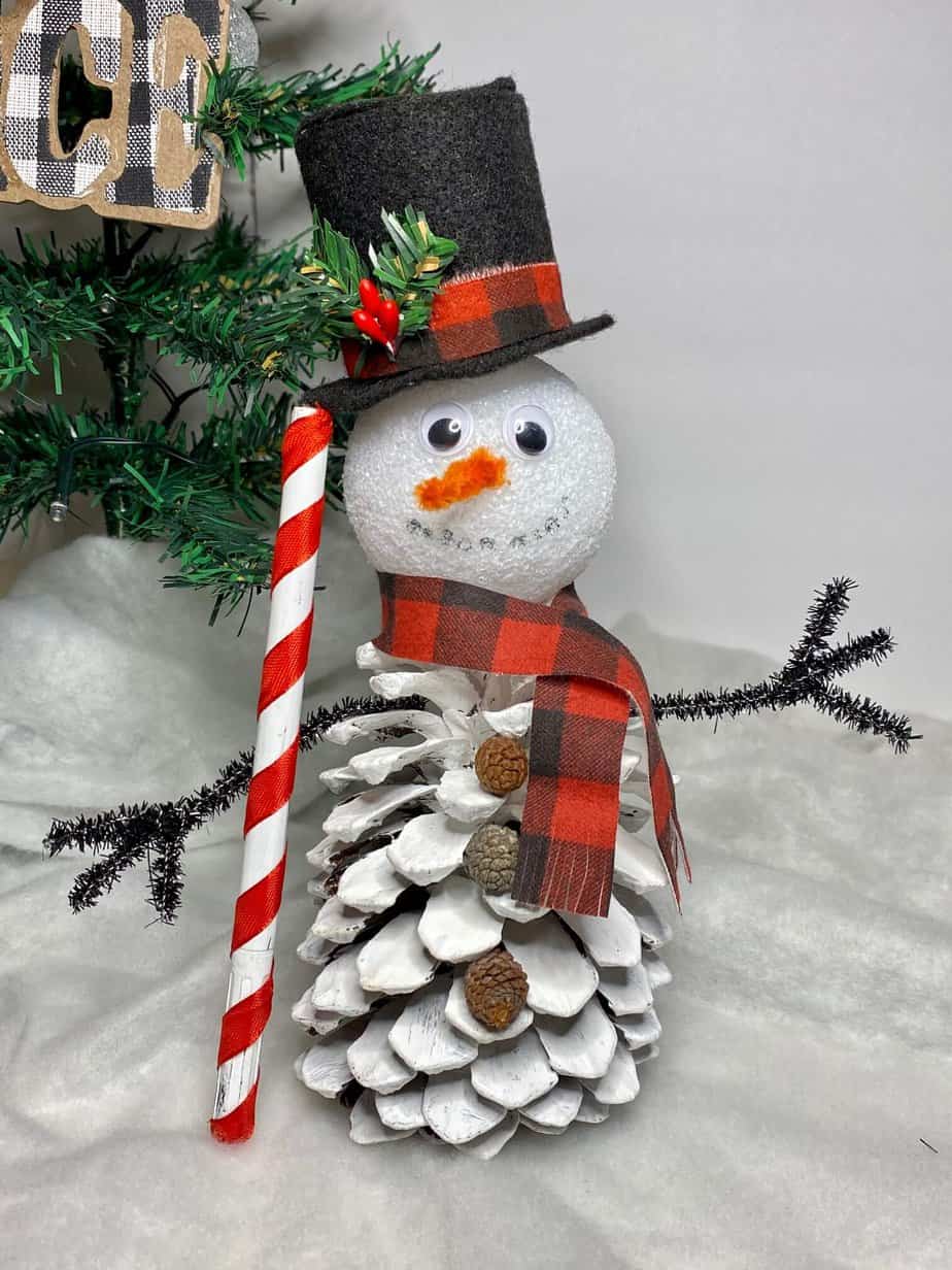 Pine cone snowman called frosty the snowcone. Christmas craft for kids using nature materials.