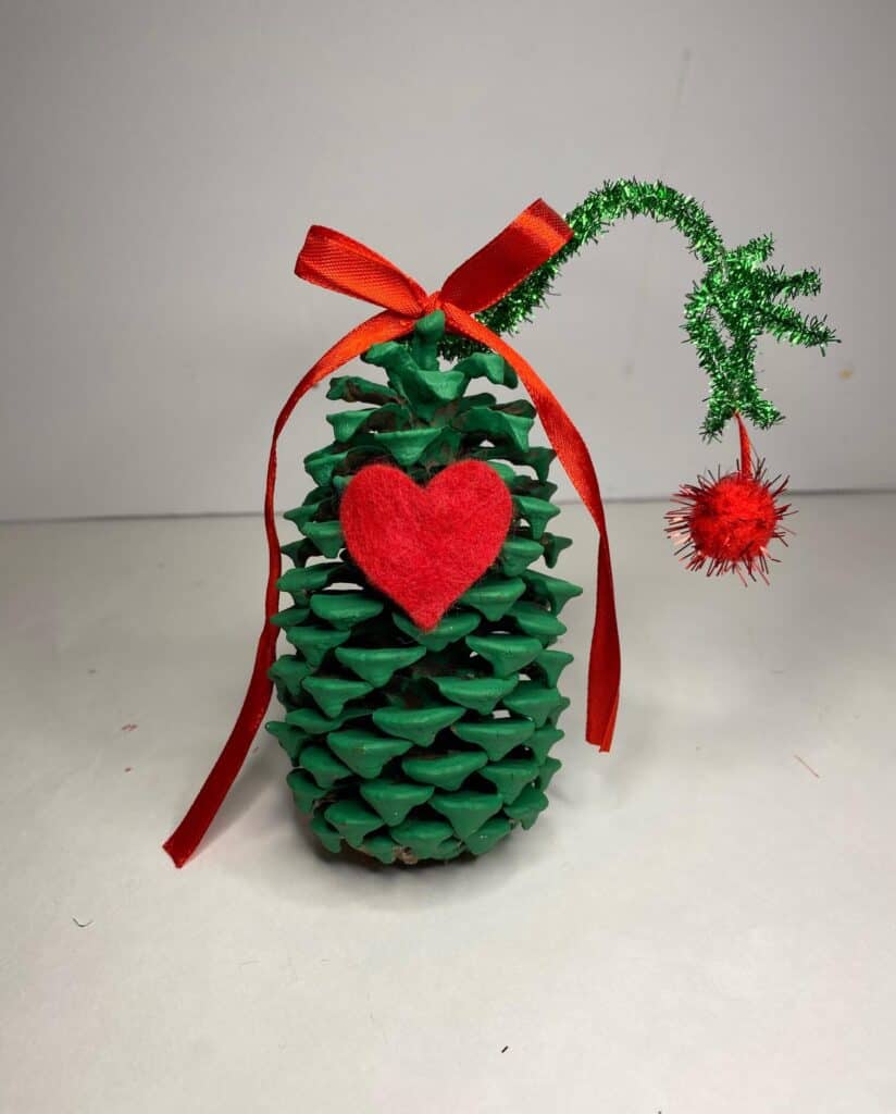 The pine cone grinch who stole christmas. Kids nature craft inspired by the the grinch hand decor.