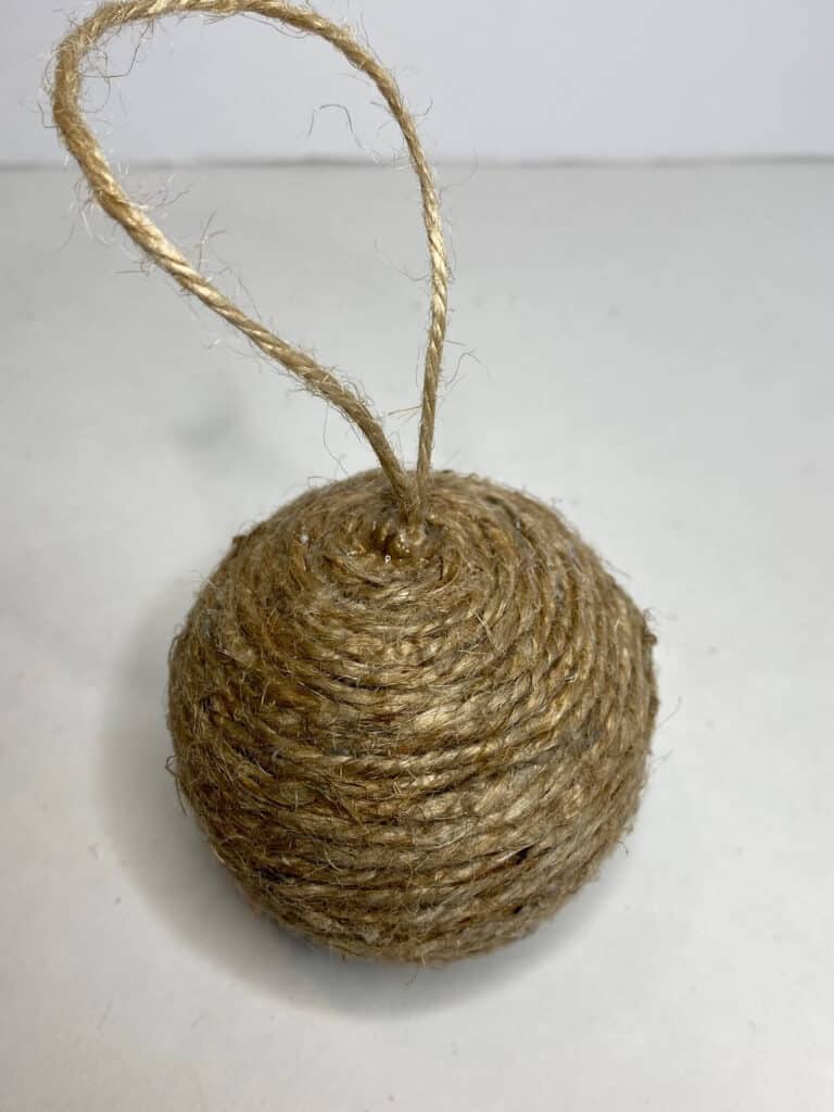 Twine ball entirely wrapped into a handmade Christmas ornament with a twine loop to hang on the tree.
