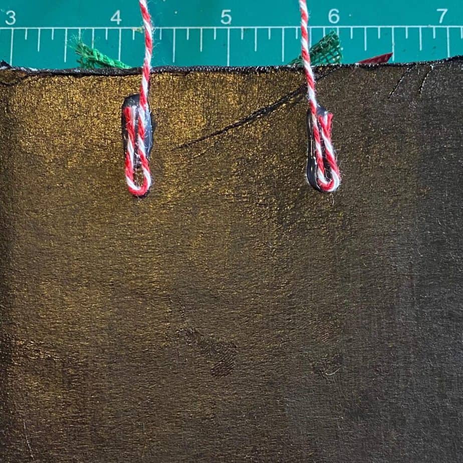 Back of the piece of cardboard painted black with a piece of bakers twine glued as a string to hang the ornament on the Christmas tree.
