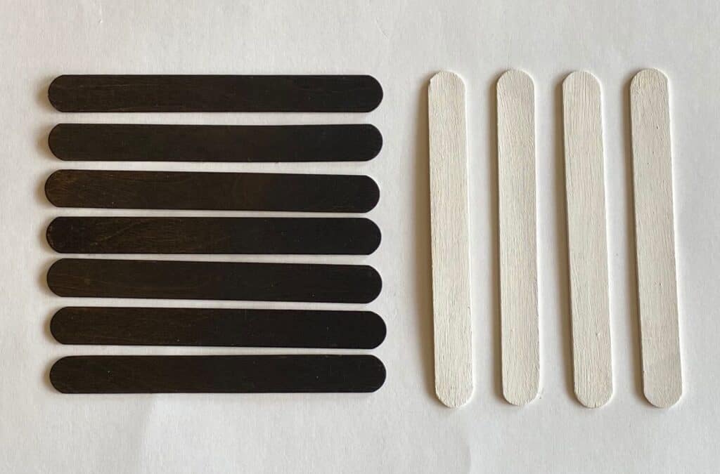 Black and white painted giant popsicle sticks.  7 black and 4 white.