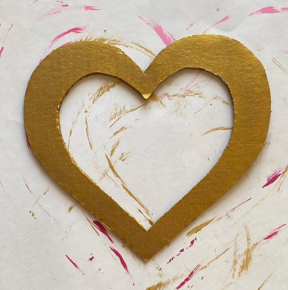 Cardboard heart with the center cut out, painted metallic gold.