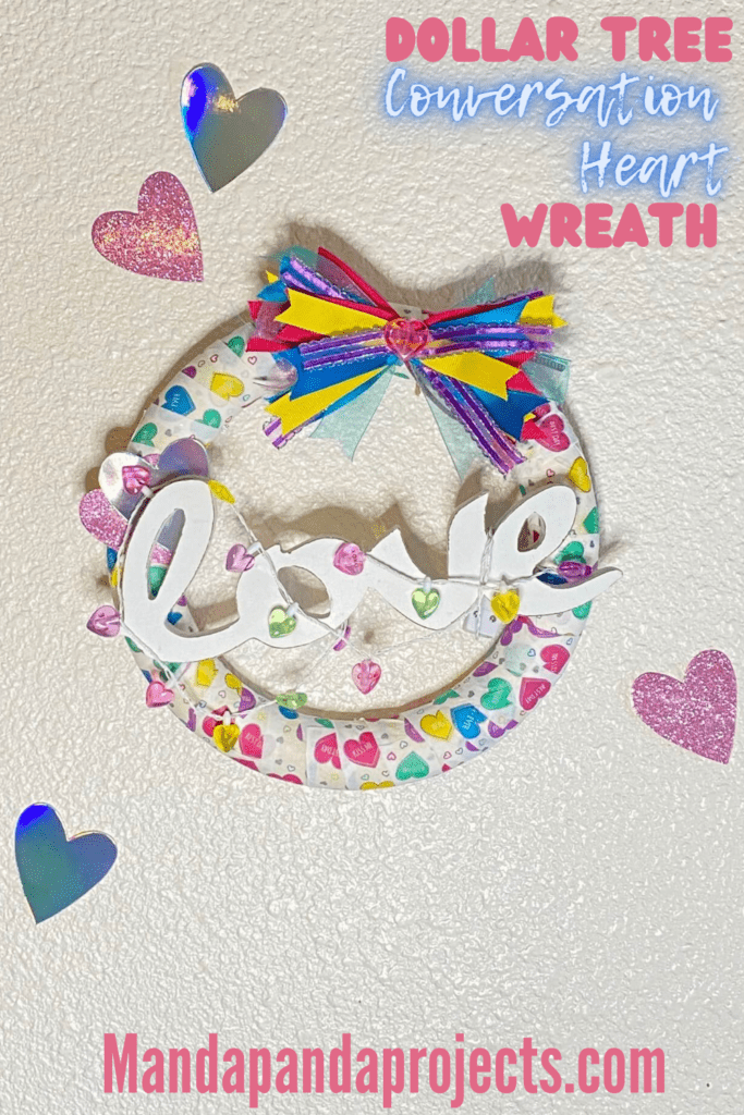 Fun and colorful Dollar Tree Conversation Heart Napkin Foam Wreath with a white wooden "love" sign for a Valentines Day craft decor for your home.