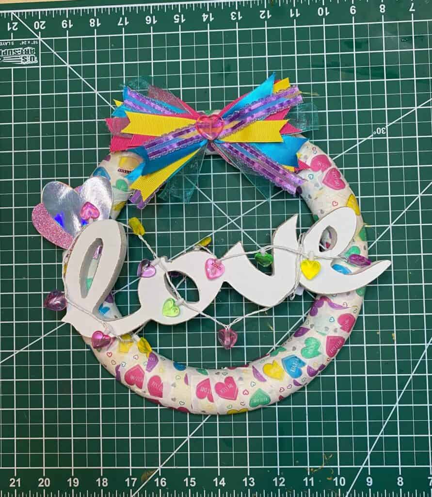 Completed project of the Fun and colorful Dollar Tree Conversation Heart Napkin Foam Wreath for a Valentines Day craft decor for your home.