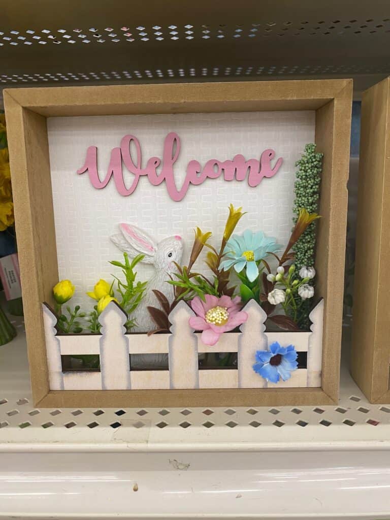 Easter bunny "welcome" shelf sitter with a white picket fence and spring flowers.