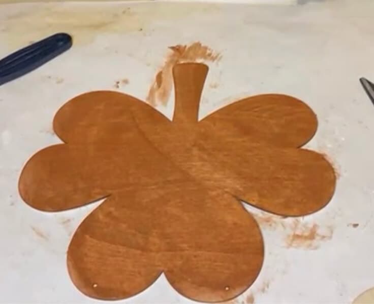 Use brown paint or stain to cover the unfinished wood surface of the shamrock.