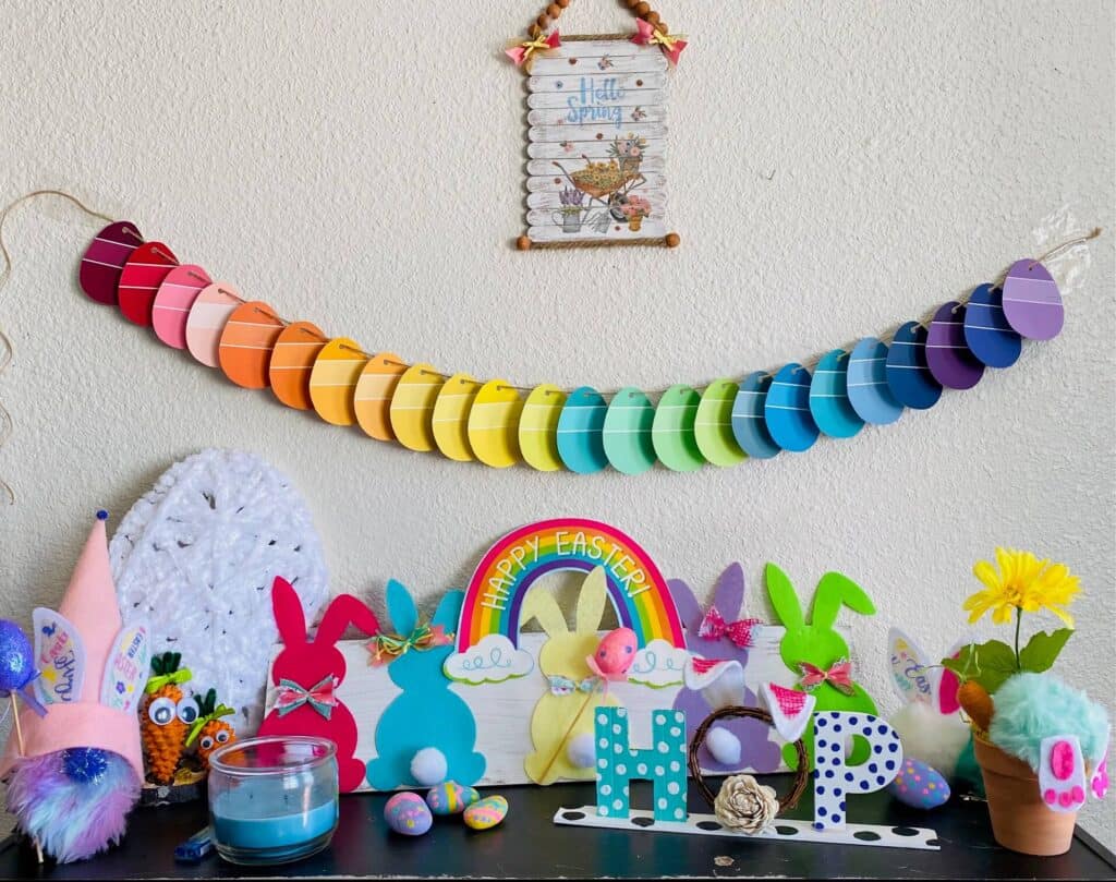 Colorful display of DIY easter decor with bunnies and easter eggs and the HOP sign, all with colors of the rainbow.