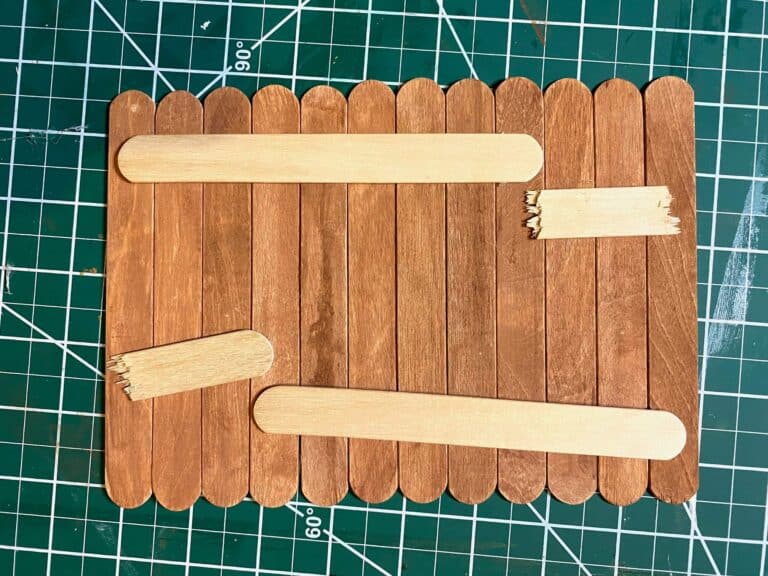 Stain the popsicle sticks brown, and glue them together lined up using another popsicle stuck to secure them.