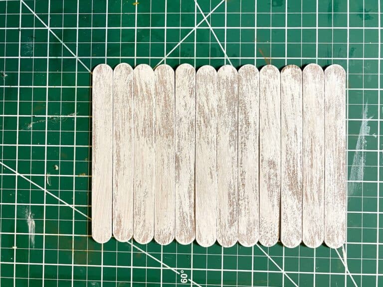 Dry brush the popsicle sticks white with a chip brush to give them a white wash look.