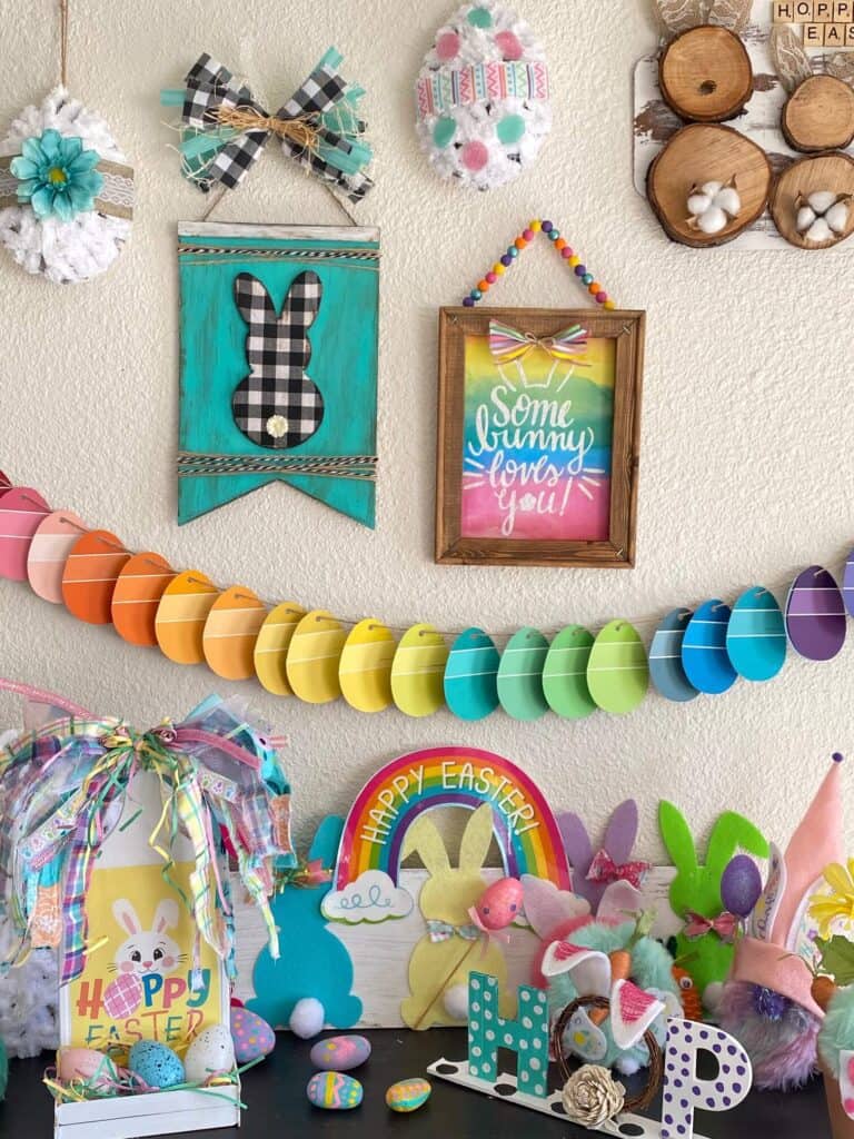 Gallery wall and bookcase filled with colorful DIY Easter crafts and decor with a rainbow easter egg banner.