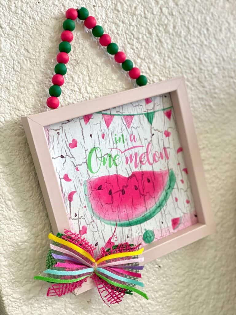Make a mini bow to add to the dollar tree one in a melon napkin frame for decoration.