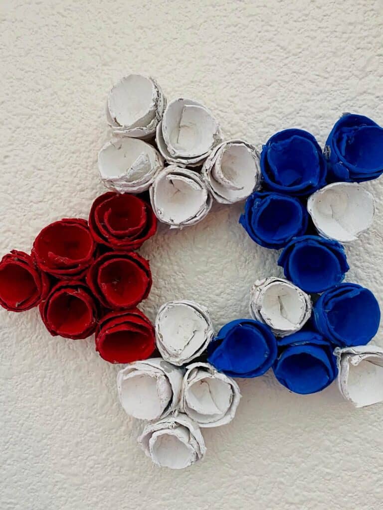 Patriotic Egg carton star wreath made with red white and blue egg cups for the 4th of July DIY Decor.