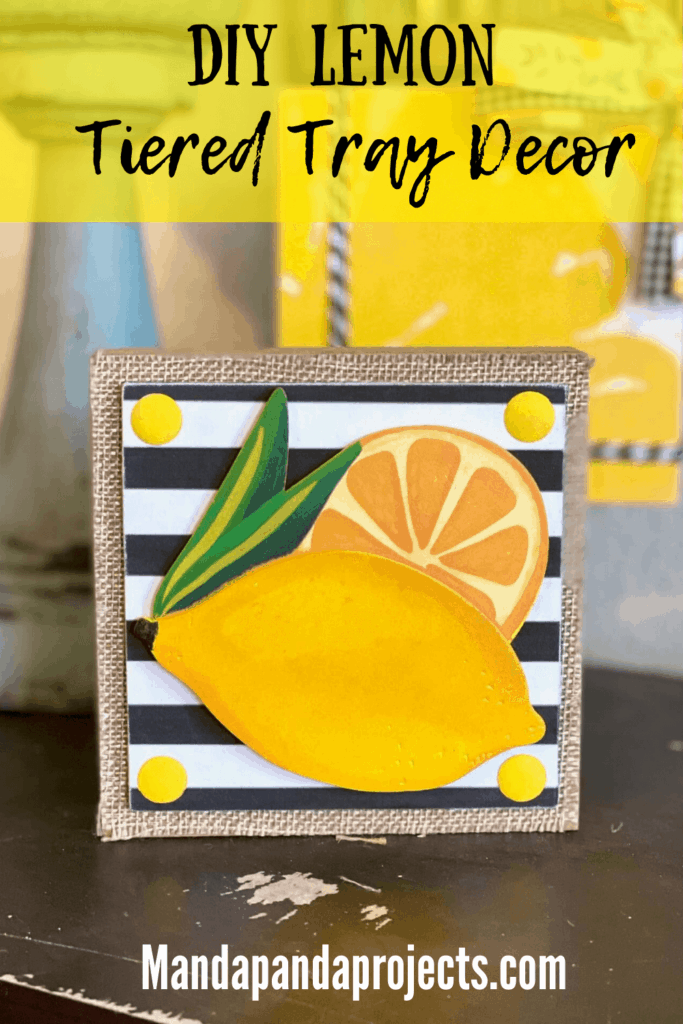 Lemon and lemon slice wooden cutout on a small wooden block with a black and white striped background on top of burlap.