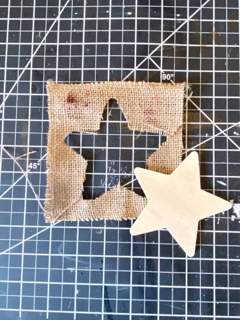 Wooden star cutout next to a piece of burlap with a star cut out of it.